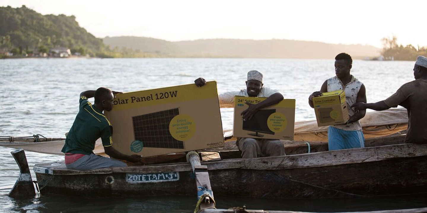 Die Solarsysteme von Mobisol werden in Afrika mit einem Boot über den Fluss transportiert. 