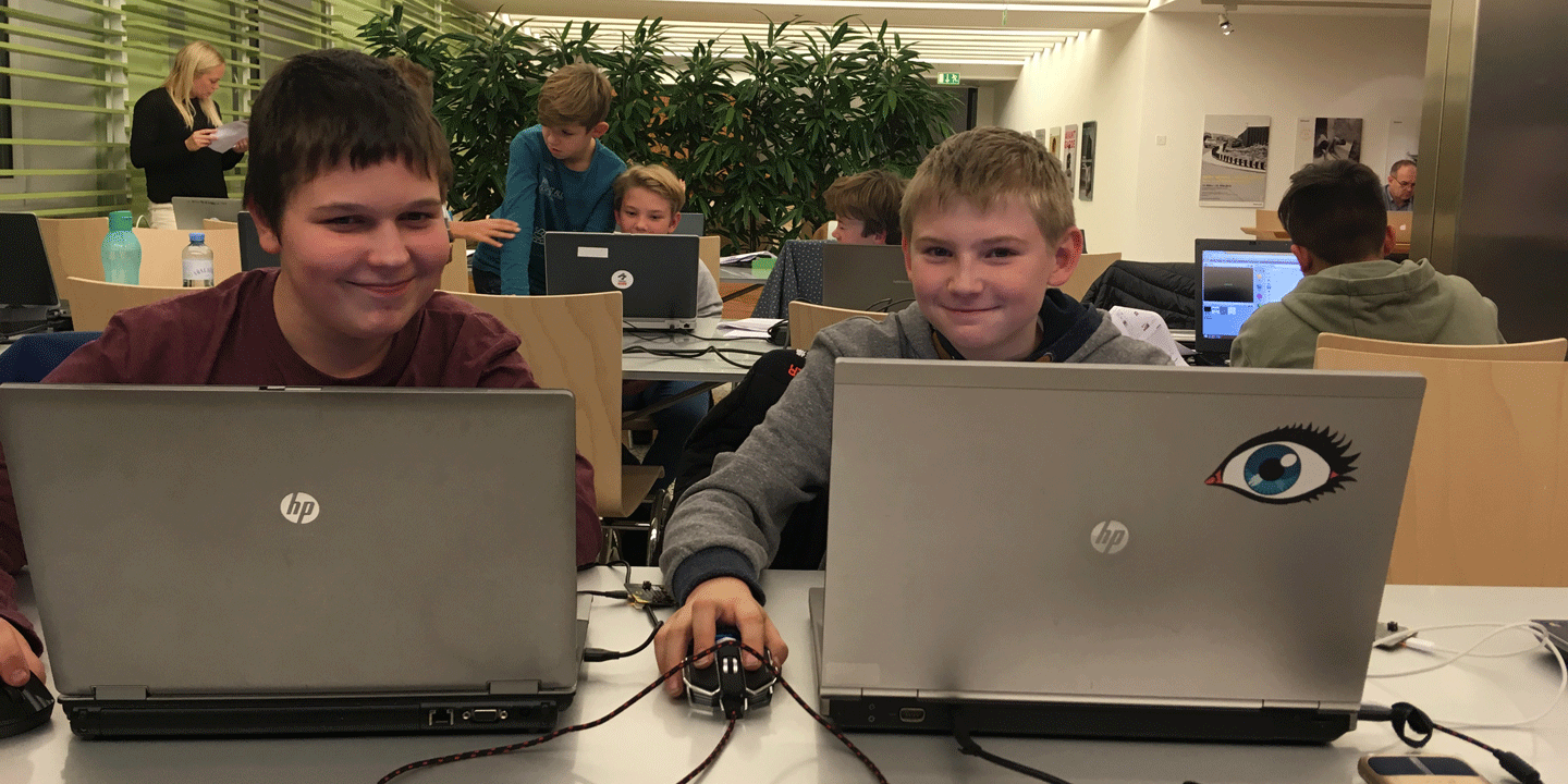 Zwei Burschen sitzen vor ihren Computern und programmieren was das Zeug hält.