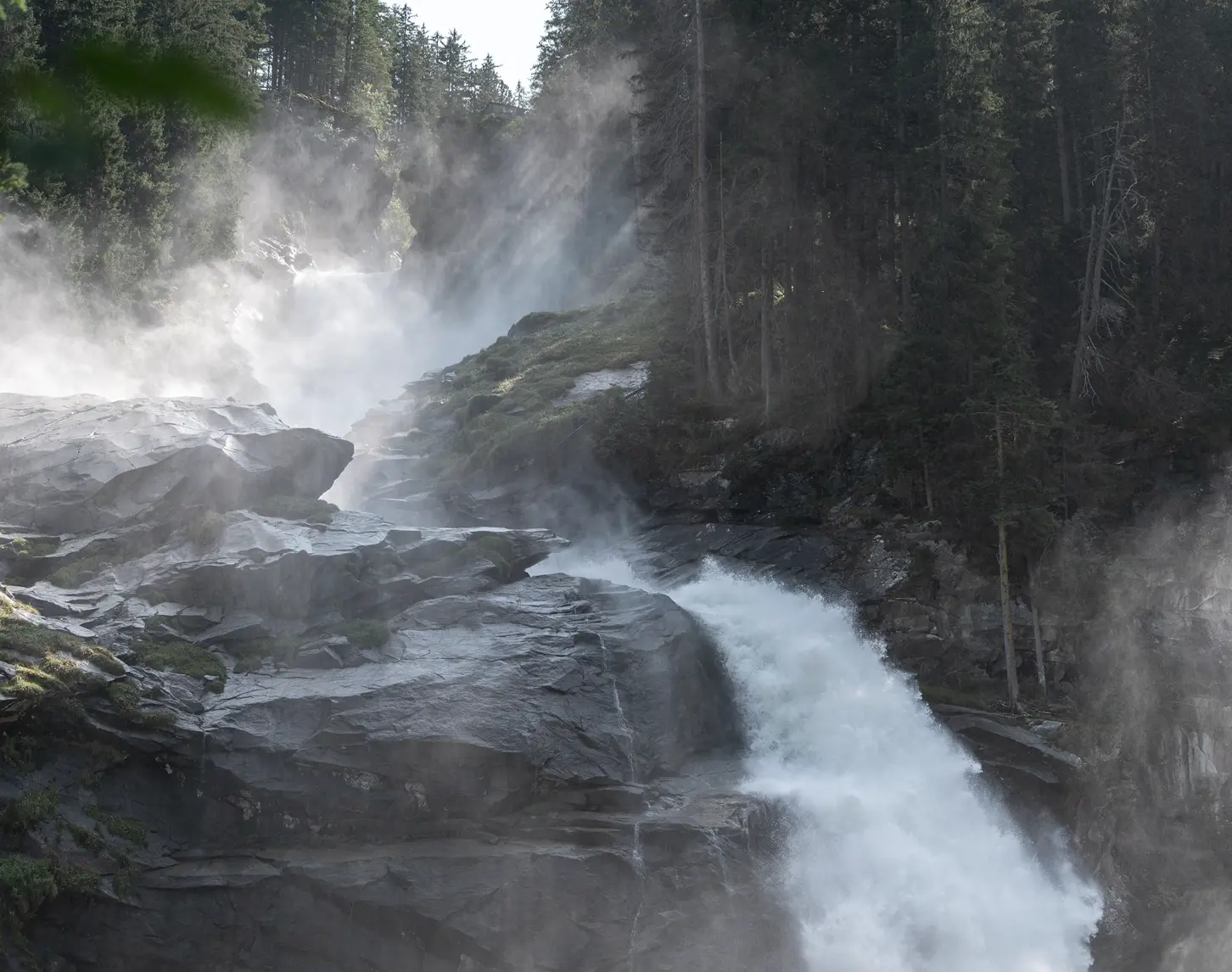 We look out over a waterfall, rocks and a mystical-looking forest.
