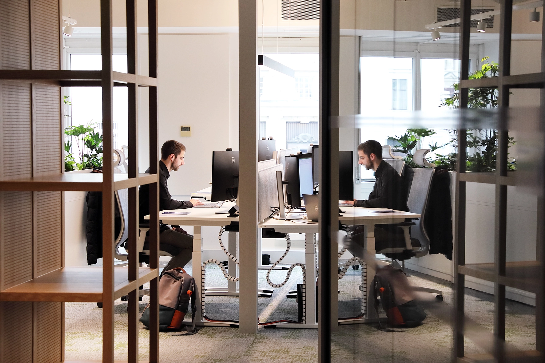 A man is sitting in a modern office and working on a computer.