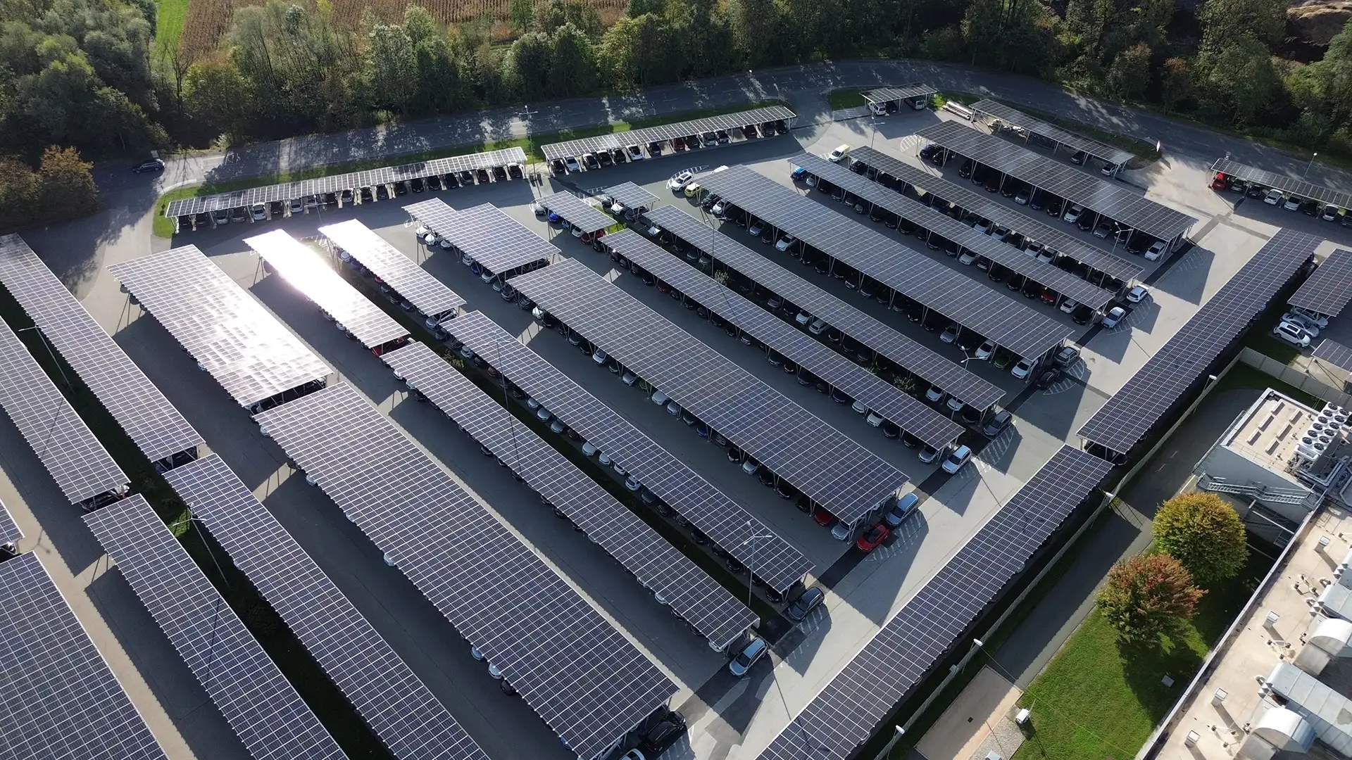 Carport-Photovoltaikanlage von VERBUND auf einem Firmenparkplatz bei sonnigem Wetter.