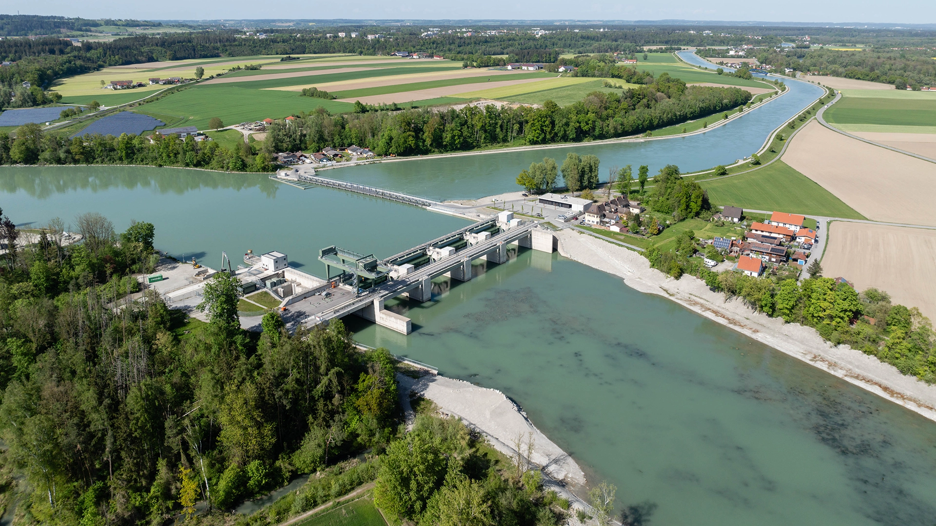 The photo shows the Jettenbach hydropower plant from above in bright sunshine.
