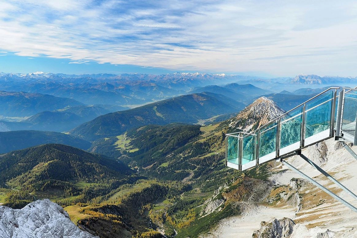 Eine Aussichtsplattform aus Glas, die einen Panoramablick über die Berge bietet.