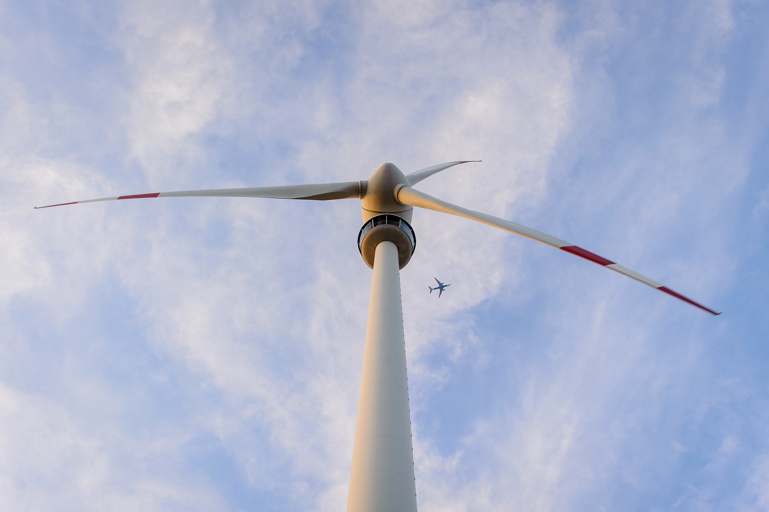 Wir blicken von unten auf ein imposantes Windrad.