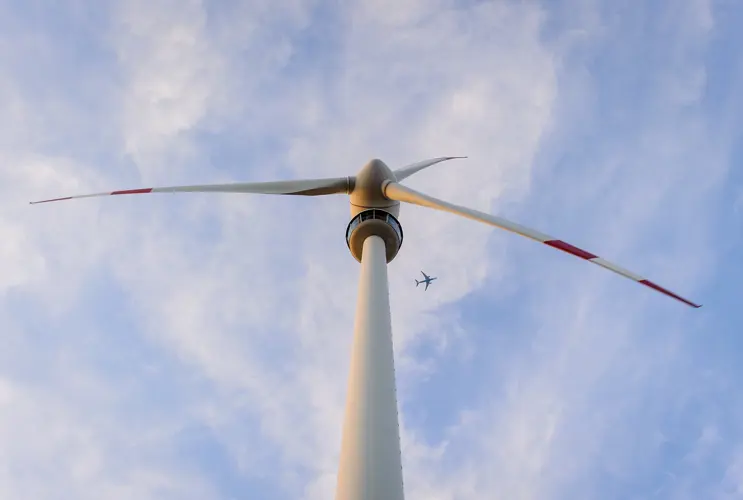 We are looking up at an impressive wind turbine from below.
