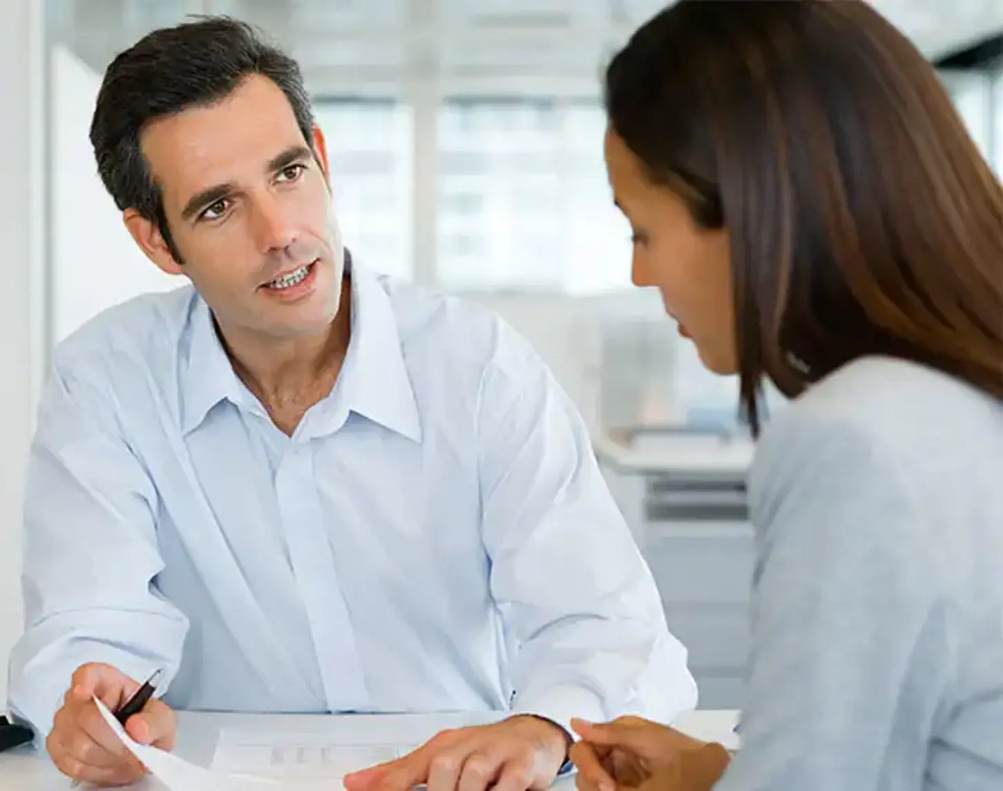 A man and a woman are having a conversation in an office.