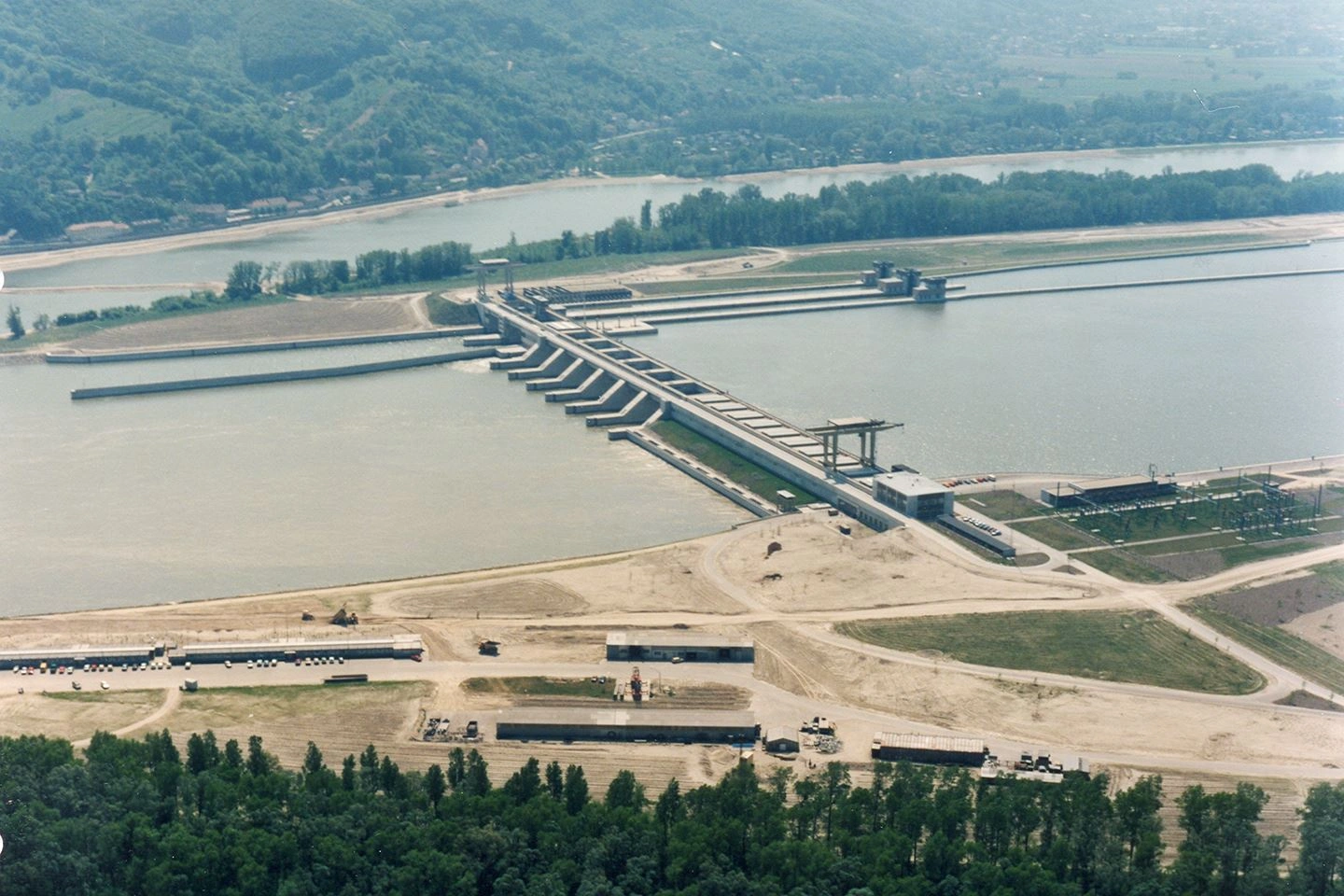 A historical bird's eye view of the construction of the Greifenstein power plant. The Danube can be seen with the dam already constructed. The construction site can still be seen on the right bank.