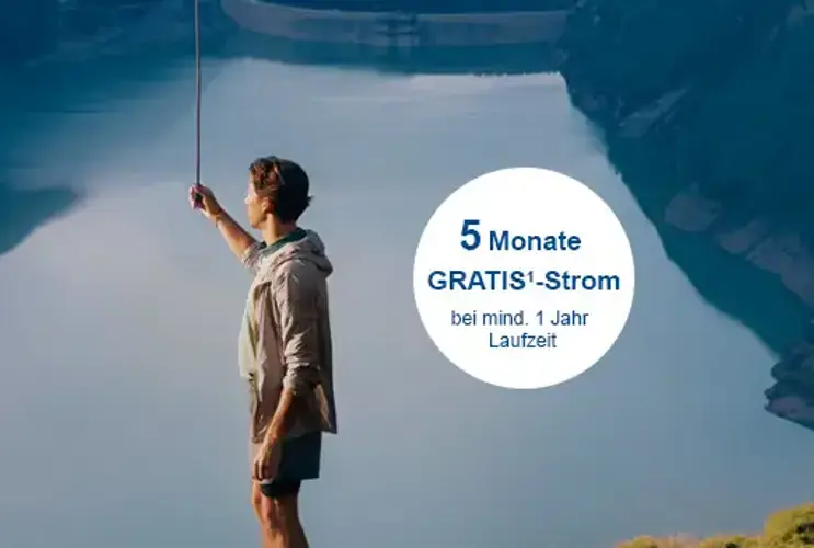 Mann steht auf einem Berg vor einem Stausee und hält eine Zugschnur einer Lampe die von oben im Bild reinreicht.