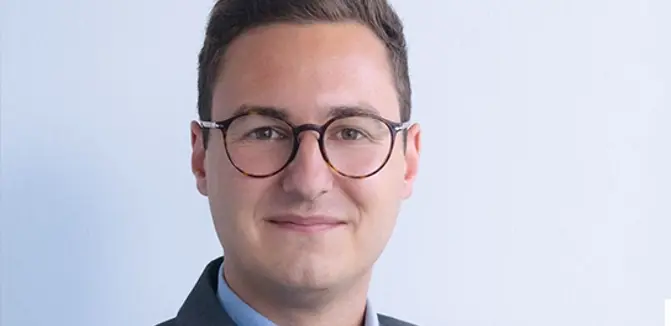 Lukas Assmair, Head of Procurement bei NÖM AG lächelt in die Kamera.