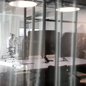 Wir blicken in ein modernes Büro in dem Menschen arbeiten.