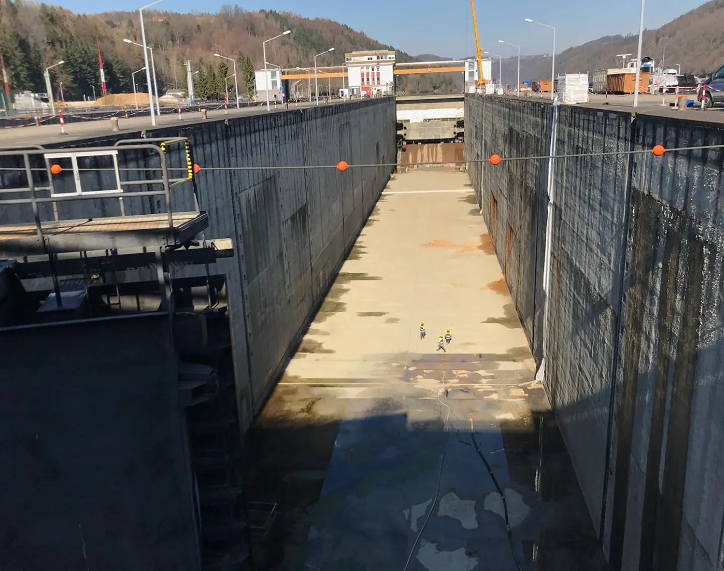 Wir blicken hinab auf die Schleuse eines Wasserkraftwerks.